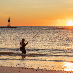 Person surf fishing at dusk