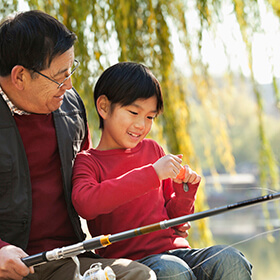 Child fishing with his grandfather