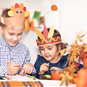 Two kids making Thanksgiving decorations