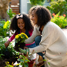 Mother and daughter tending a flower garden