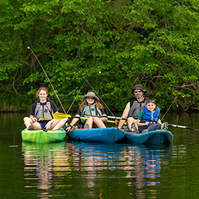 Family fishing while kayaking