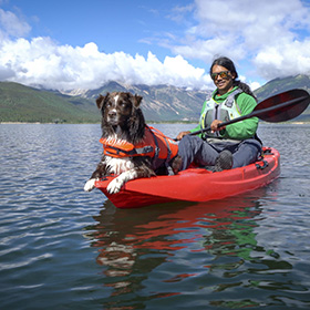 Man kayaking with his dog