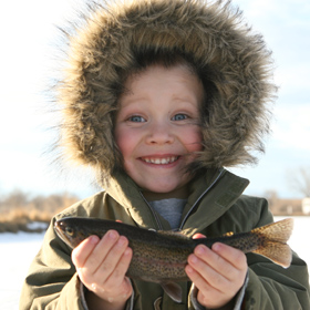 kid holding a fish in the snow