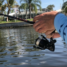angler holding a open face rod and reel