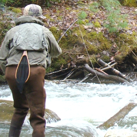angler fishing in a river using different bottom fishing rigs for trout