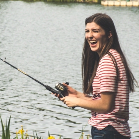women angler fishing with a out of state fishing license